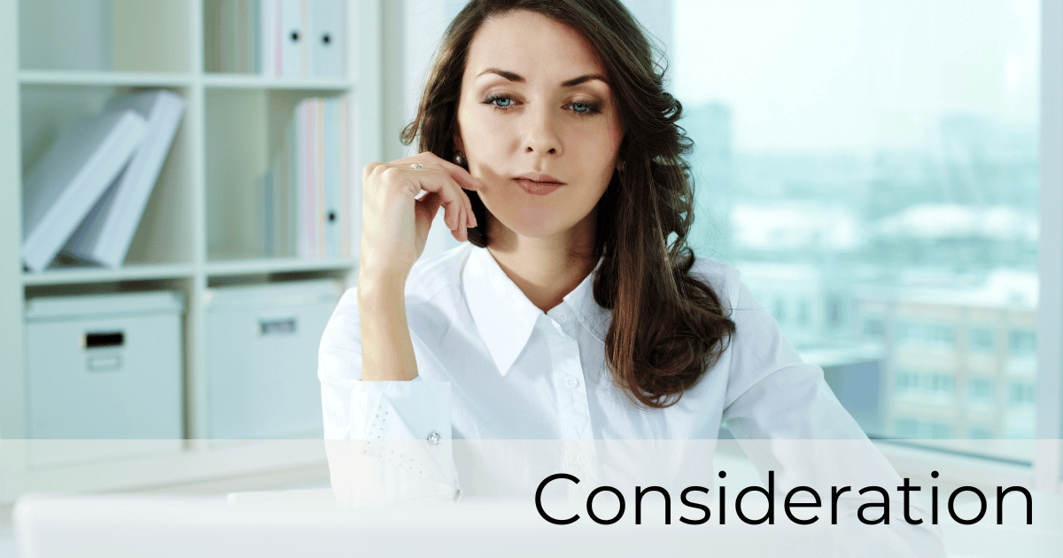 A woman sitting at her computer considering what to do in the consideration stage of the buyers journey.