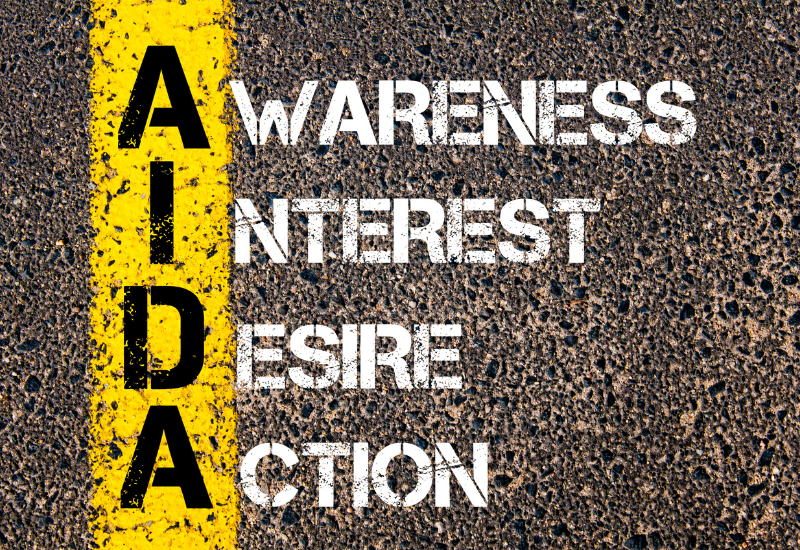 AIDA Copywriting Framework - AIDA acronym written on pavement with each letter spelled out as Awareness, Interest, Desire, Action.