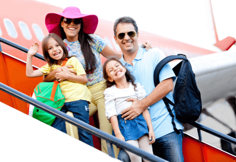 family taking a picture while boarding an airplane