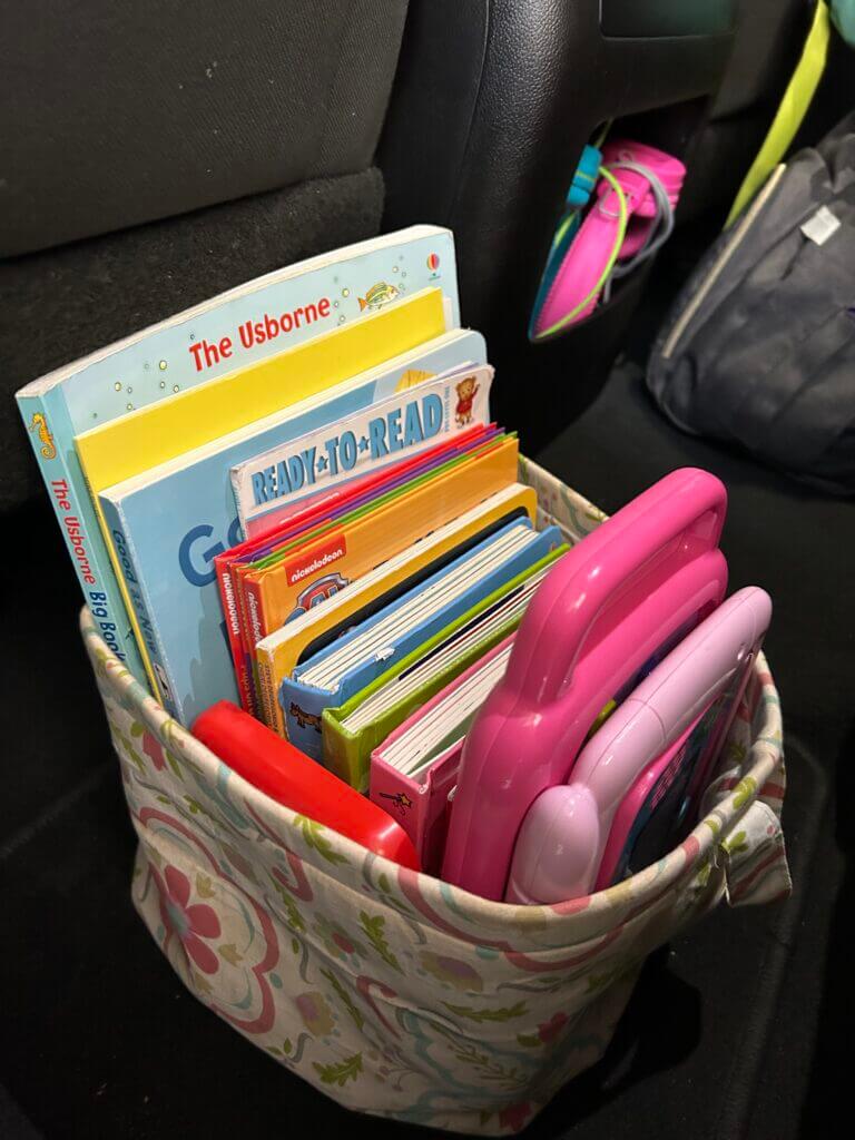 Activity bag with books, sticker books, look and find books and computer games for long roadtrips with kids.