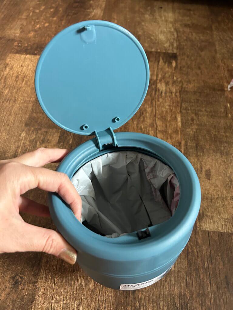 Car trash can with push-top closure.